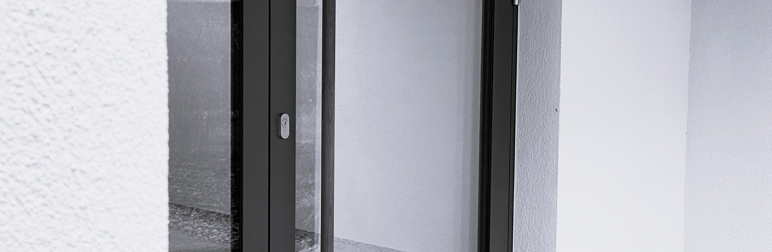 Kontakt, Eingangstür des HOKI Partner Büros mit schlichter Glas Metall Konstruktion und klarer architektonischer Detailausbildung.